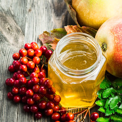 Honey, apples and berries on wooden table. Selective focus, copy space.