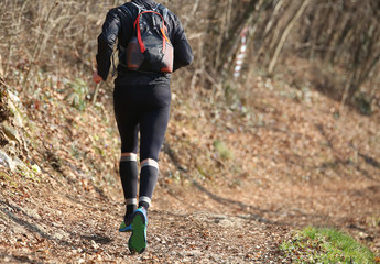 legs of a runner during the country race in the middle of the fo
