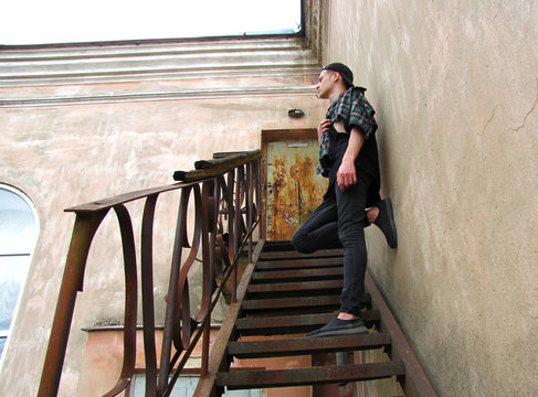 teenager stands on the stairs of an abandoned building