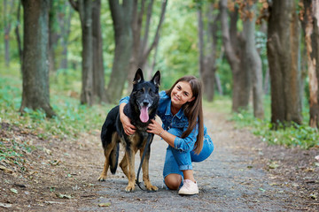 Portrait of a girl with a dog by a German shepherd in the summer.