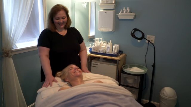 Masseuse and client both smile and laugh as the facial comes to its end.