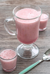 Berry drink pink in glass glasses on a wooden table. Selective focus