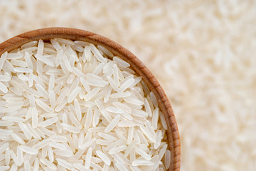 Close up of long parboiled rice in wooden bowl on blurred background. Healthy food. Top view, high resolution product