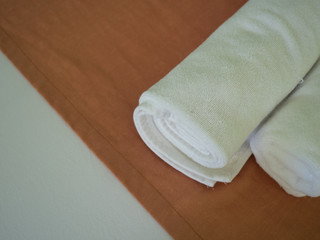 Obraz na płótnie Canvas Roll of white towel on the bed