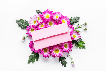 Floral pattern. Bouquet of pink flowers and envolope with greeting card on white background top view