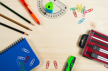 Top view of blue notebook, pen, pencils, protractor, colorful paper clips, set for drawing  and ...