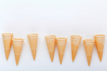 Flat lay ice cream cones collection on white wooden background . Blank crispy ice cream cone with copy space for sweets menu design.