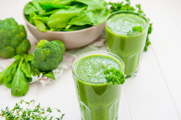 Fresh green Spinach smoothies in glass on the white wooden background. Healthy lifestyle concept. Selective focus. Backlight. Copy space.