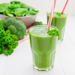 Fresh green Spinach smoothies in glass on the white wooden background. Healthy lifestyle concept. Selective focus. Backlight. Copy space.