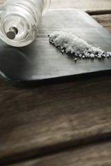 Salt shaker and salt on black slate plate