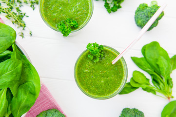Top view Fresh green Spinach smoothies in glass on the white wooden background. Healthy lifestyle concept. Selective focus. Flat lay. Copy space.