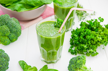 Fresh green Spinach smoothies in glass on the white wooden background. Healthy lifestyle concept. Selective focus. Backlight. Copy space.