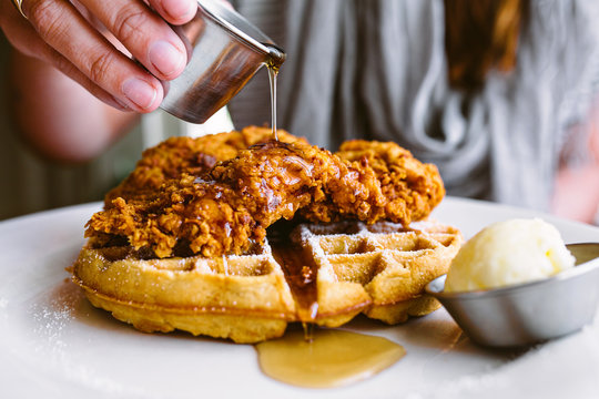 Woman Glazing Chicken On Waffle