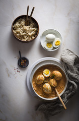 Egg curry in a ceramic bowl on top view