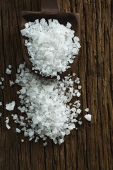 Naklejka premium Salt in spoon on wooden table