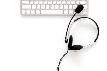 Workplace in call center. Headphones on keyboard on white background top view copyspace