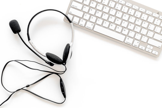 Workplace in call center. Headphones on keyboard on white background top view copyspace