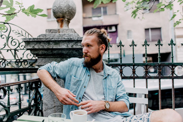 Portrait of a young bearded man in a cafe