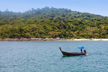 Thailand beautiful sea landscape with boat and umbrella with copy space. Sea transparent and clear water. Useful illustration or background for travel article or holiday content