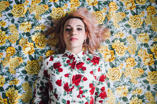 woman lying on a floral pattern
