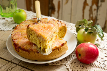 Apple pie and apples on a wooden table. Rustic style, selective focus.