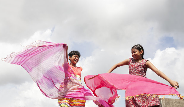 Two girls playing with shawls