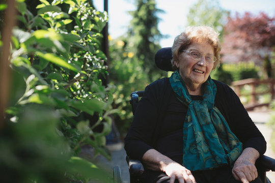 Smiling, caucasian senior woman outside in wheelchair