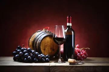 Abwaschbare Fototapete Wein Rotweinglas mit Weintrauben, Flasche und kleinem Fass