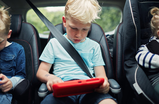 Children using electronic tablets in the car