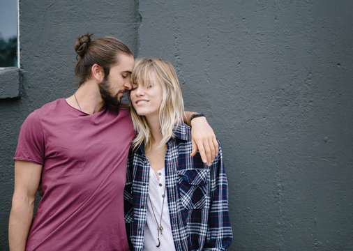 Couple standing by wall being intimate