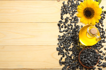 Sunflower oil, seeds and flower on white wooden background. top view with copy space