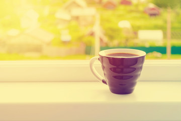 Toned black cup of coffee for breakfast with beautiful view from window