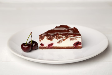 Sweat cake with cherry on plate on wooden background
