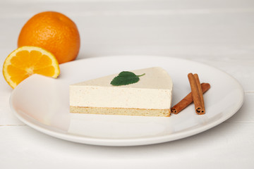 Sweat cake with orange and cinnamon on plate on wooden background