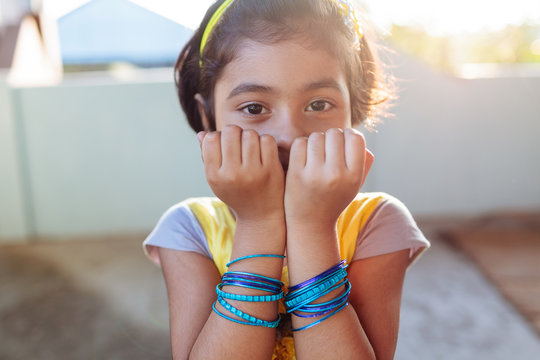 Portrait of little girl showing her blue bangles