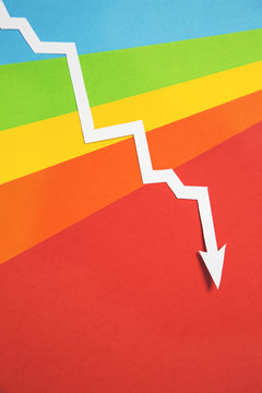 White arrow heading downward on rainbow background...