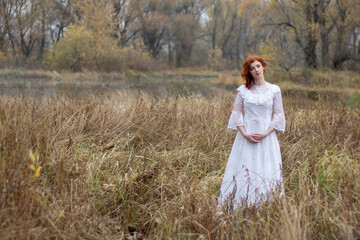 Girl with red hair  in a forest in autumn.