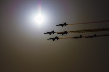 Turkish acrobatic aviation squadron flying over Izmir (Turkey). Airplanes are backlighted against the sun, in front of which they are passing