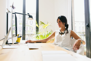Young female working with her computer in a beautiful office.