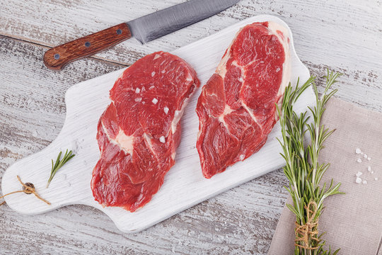 Raw fresh beef steak on a white cutting board