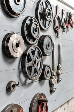 Gear wheels hanging on a wall of workshop