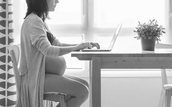 Pregnant working with the computer in the living room