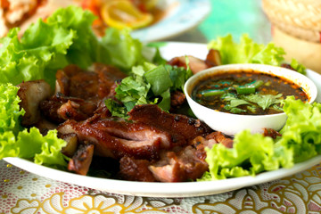 Charcoal-boiled pork neck served with spicy sauce and vegetable. 