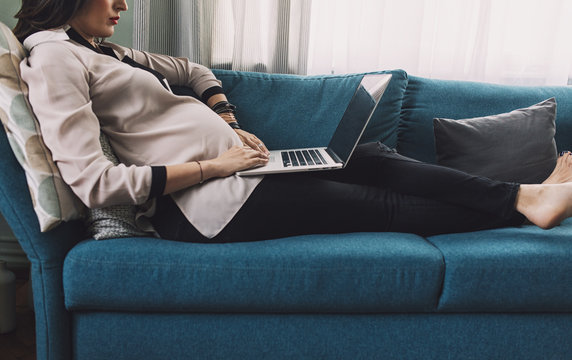 Pregnant Woman Working on a Couch