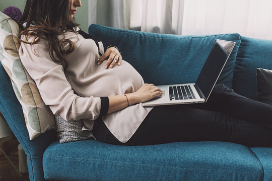 Pregnant Woman Working on a Couch