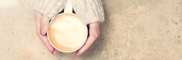 Girl holding cup of coffee with latte art. Leasure time concept. Pastel colors