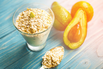 Healthy food. Dietary breakfast or snack. Green smoothies from yoghurt, avocado, oatmeal. On blue wooden table, with ingredients. Selective focus