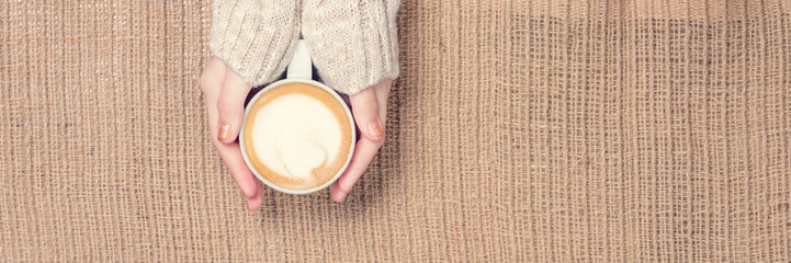 Girl holding cup of coffee with latte art. Leasure time concept. Pastel colors