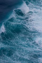 Große Welle mit Gischt in blauem Wasser
