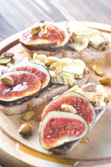 Slices of bread with camembert, figs and pistachios